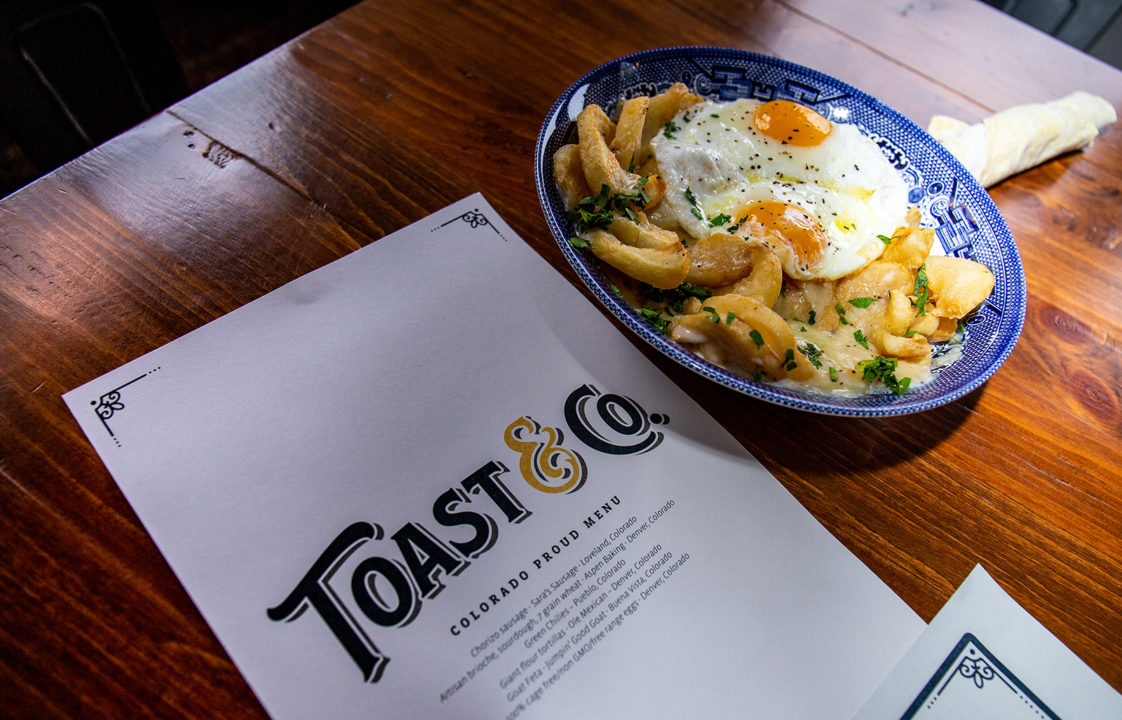 A menu for the restaurant Toast & Co. with a plated menu item featuring french fries and eggs